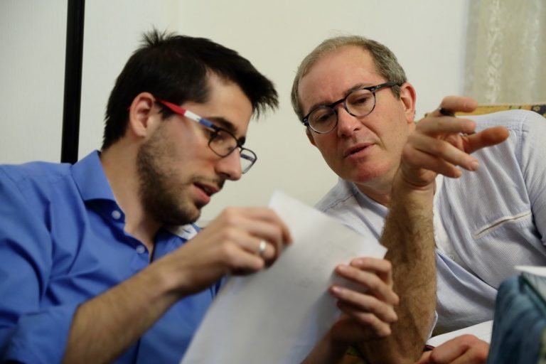 Dos personas conversando y reflexionando juntas sobre un texto.
